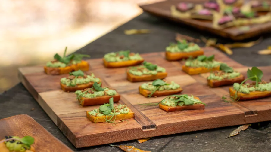 Beautifully arranged Māori-inspired canapés served outdoors on wooden boards at Te Pā Tū