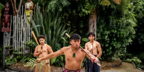 Group of Māori warriors performing a ceremonial challenge at Te Pā Tū