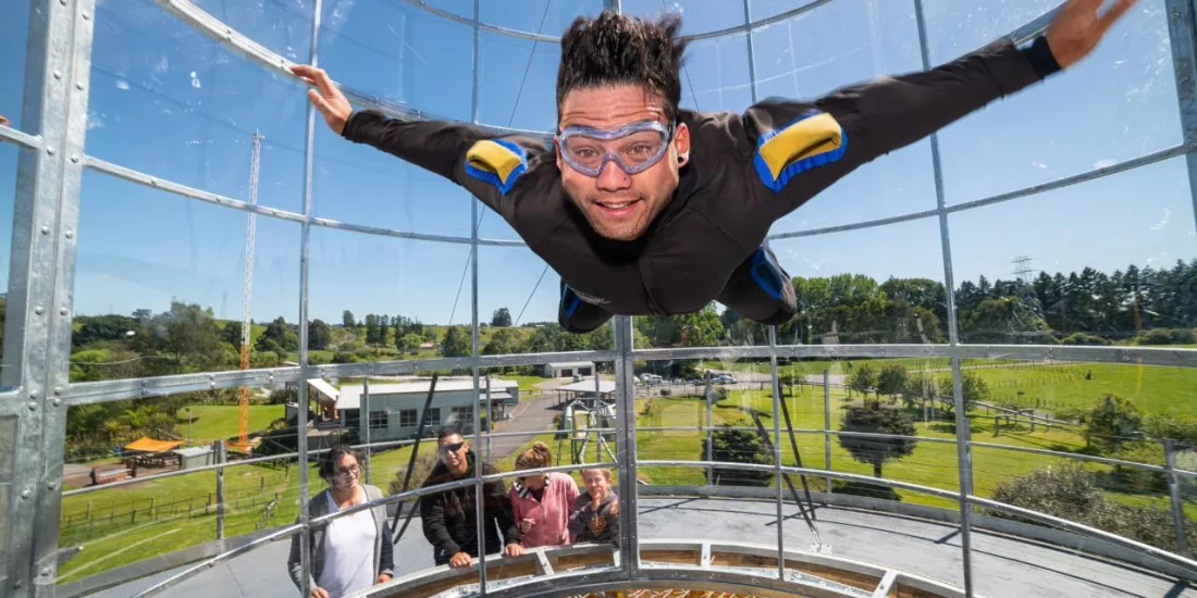 Excited flyer hovering mid-air inside Freefall Xtreme’s outdoor wind tunnel