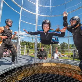 Two instructors supporting a participant during their Freefall Xtreme flying session