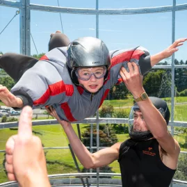 Child enjoying their first wind tunnel experience with instructor support at Velocity Valley