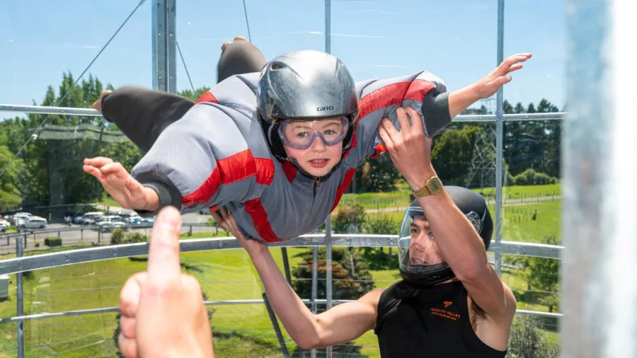 Child enjoying their first wind tunnel experience with instructor support at Velocity Valley