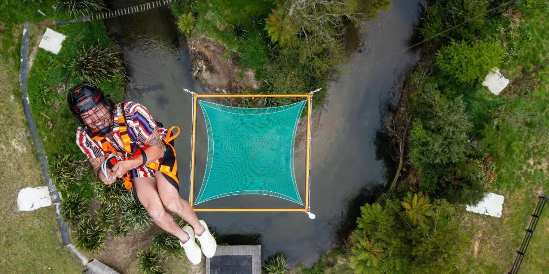 Aerial view of a person mid-air above the green Vertigo net at Velocity Valley