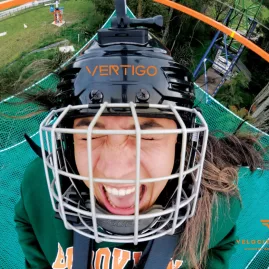 Close-up of an excited rider in helmet at the top of the Vertigo platform at Velocity Valley