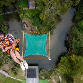Aerial view of a person mid-air above the green Vertigo net at Velocity Valley