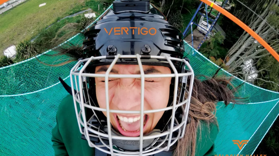 Close-up of an excited rider in helmet at the top of the Vertigo platform at Velocity Valley