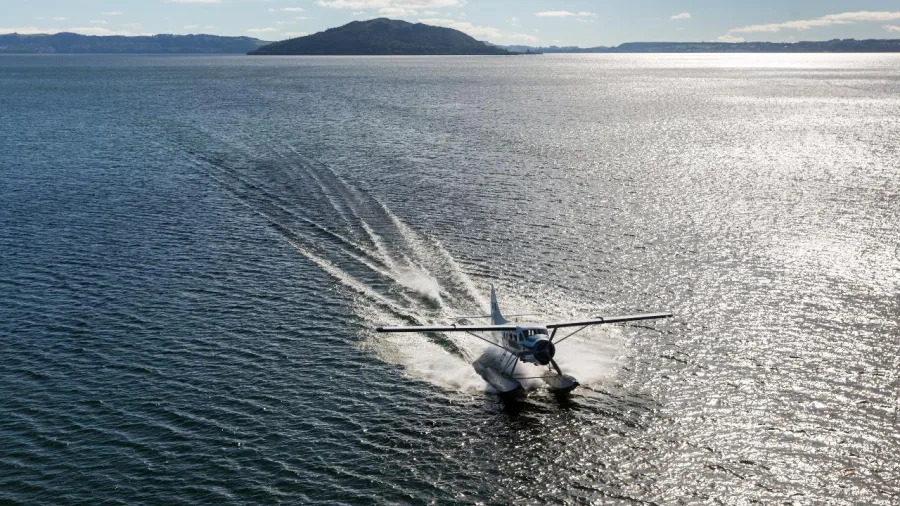Floatplane taking off from Lake Rotorua for a scenic flight over New Zealand's crater lakes