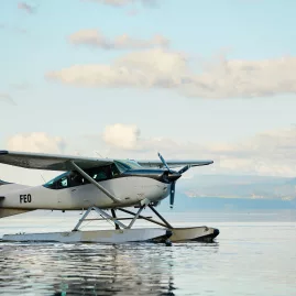 Volcanic Air Cessna floatplane floating peacefully on Lake Rotorua under soft morning skies
