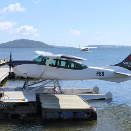 Volcanic Air floatplane docked with Mokoia Island visible in the background on Lake Rotorua