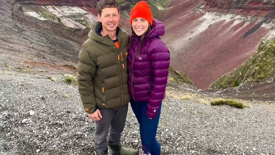 Couple posing beside the colourful crater slopes of Mount Tarawera