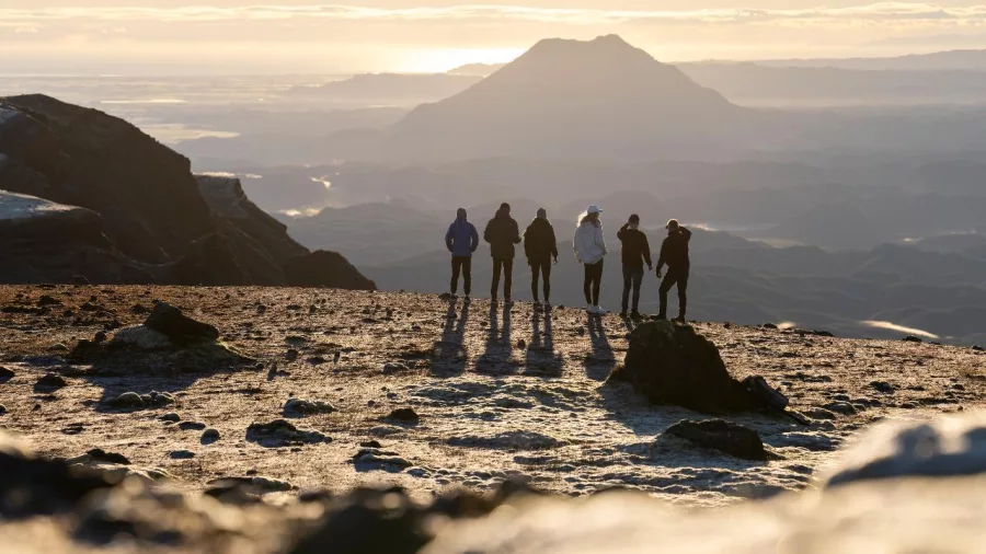Sunrise silhouette of hikers at the summit of Mount Tarawera