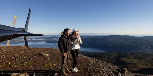 Couple standing near a helicopter on Mount Tarawera summit
