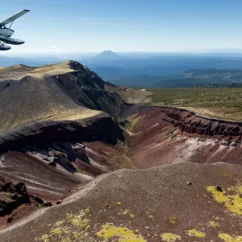 Volcanic Air Otter floatplane soaring above the vibrant crater of Mount Tarawera