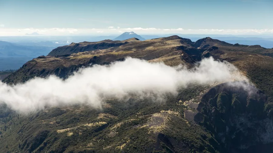 Low cloud skimming the rugged ridge of Mount Tarawera during a scenic floatplane flight