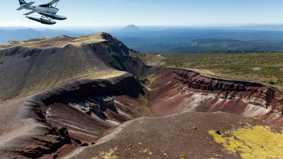 Volcanic Air Otter floatplane soaring above the vibrant crater of Mount Tarawera