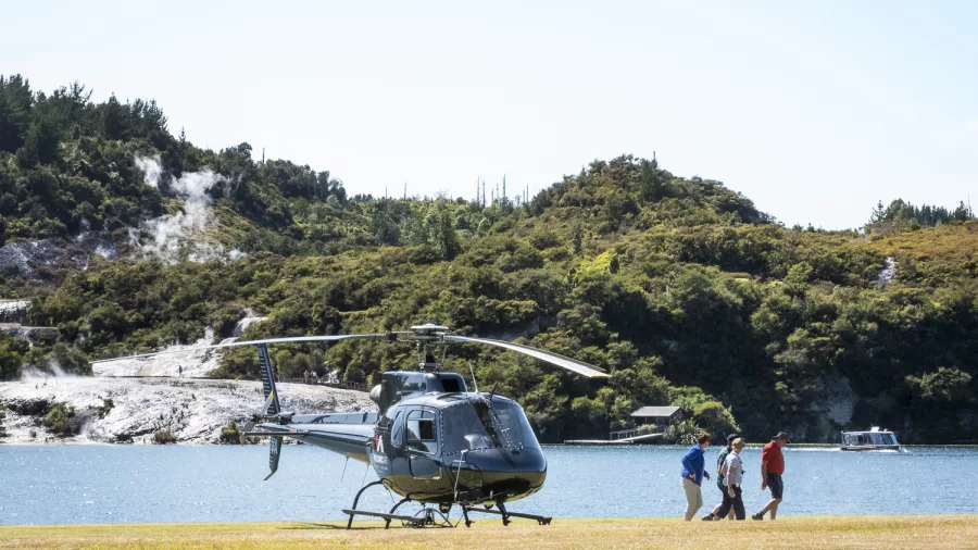 Helicopter landing near steaming geothermal terraces at Orakei Korako