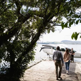 Couple walking down a jetty towards a Volcanic Air floatplane at Peppers on the Point