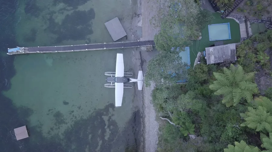 Top-down aerial view of Volcanic Air floatplane docked at Rotoiti Hot Pools jetty