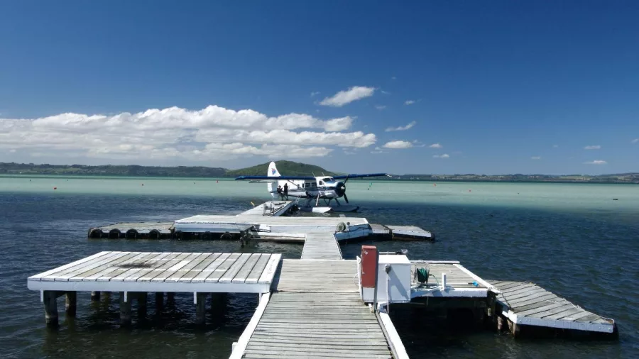 Floatplane docked on a white timber jetty over Lake Rotorua’s turquoise waters