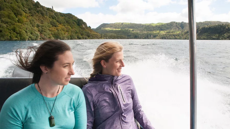 Two women enjoying a scenic boat ride across Lake Tarawera