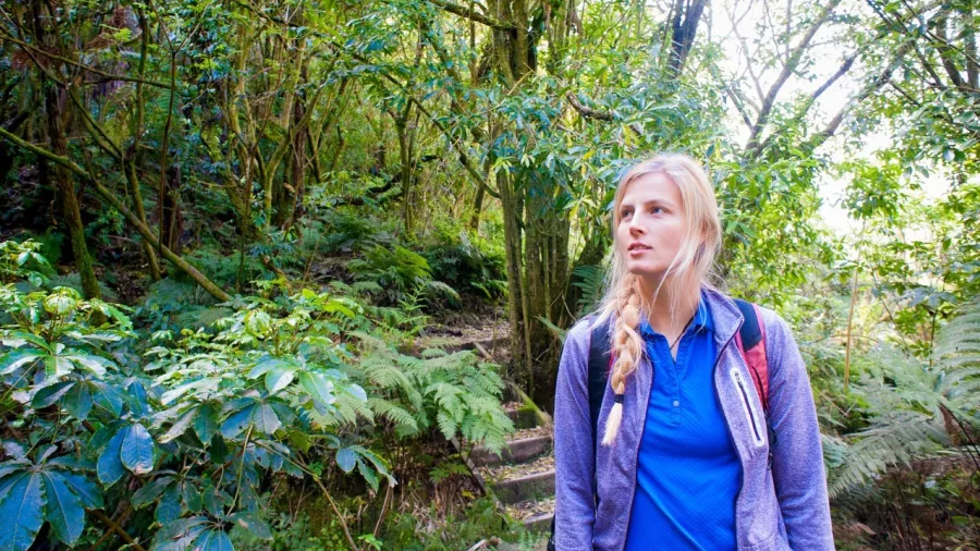 Woman hiking the Tarawera Falls trail after helicopter drop-off near Rotorua, New Zealand