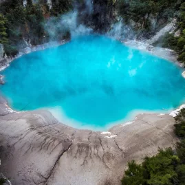 Bright blue Inferno Crater Lake emitting geothermal steam