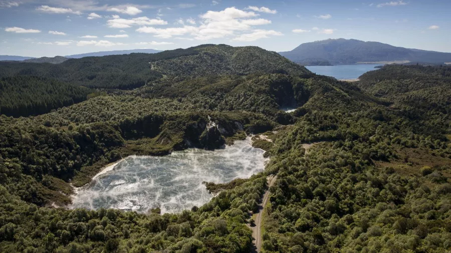 Wide aerial view of Frying Pan Lake steaming inside Waimangu Volcanic Valley