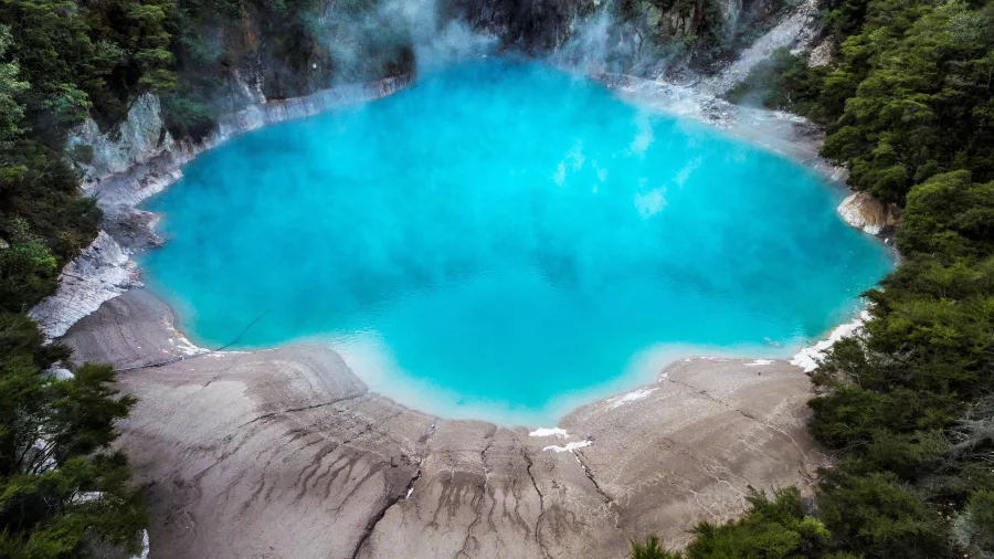 Bright blue Inferno Crater Lake emitting geothermal steam