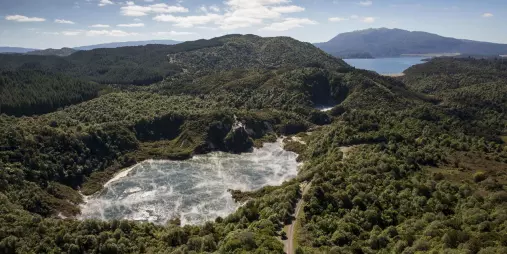 Wide aerial view of Frying Pan Lake steaming inside Waimangu Volcanic Valley