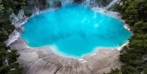 Bright blue Inferno Crater Lake emitting geothermal steam
