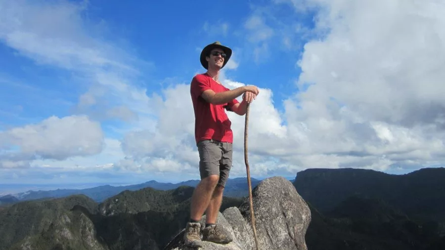 Male hiker standing proudly on the rocky summit of the Pinnacles in the Coromandel