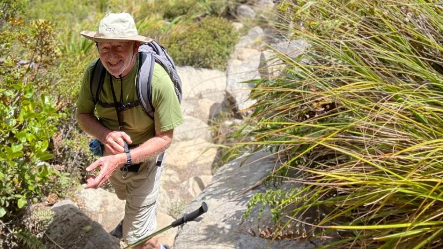 Group of hikers ascending a narrow ridge towards the summit of the Pinnacles