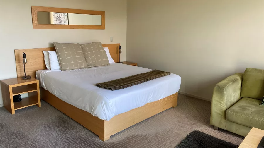 Bright, spacious boutique accommodation room with a large bed and soft furnishings