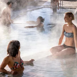Couple and friends enjoying an evening soak at Polynesian Spa, Rotorua, New Zealand