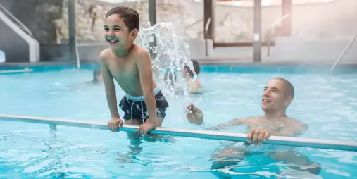 Smiling child playing in the family pool at Polynesian Spa, Rotorua, New Zealand