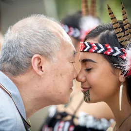 Visitor and Māori host greeting each other with a hongi at Te Puia in Rotorua