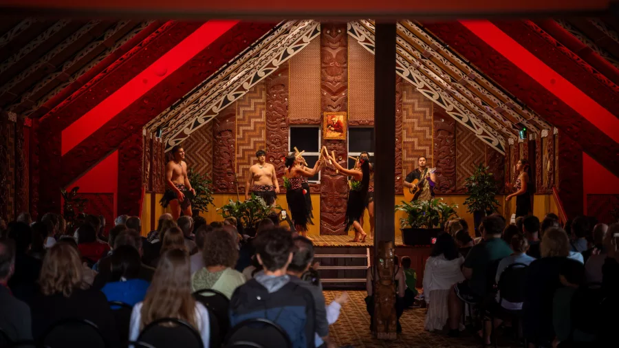 Māori performers demonstrating traditional haka stick games on stage during a cultural experience in Rotorua