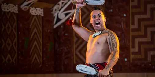 Māori performers in traditional attire presenting a haka at Te Puia in Rotorua, New Zealand