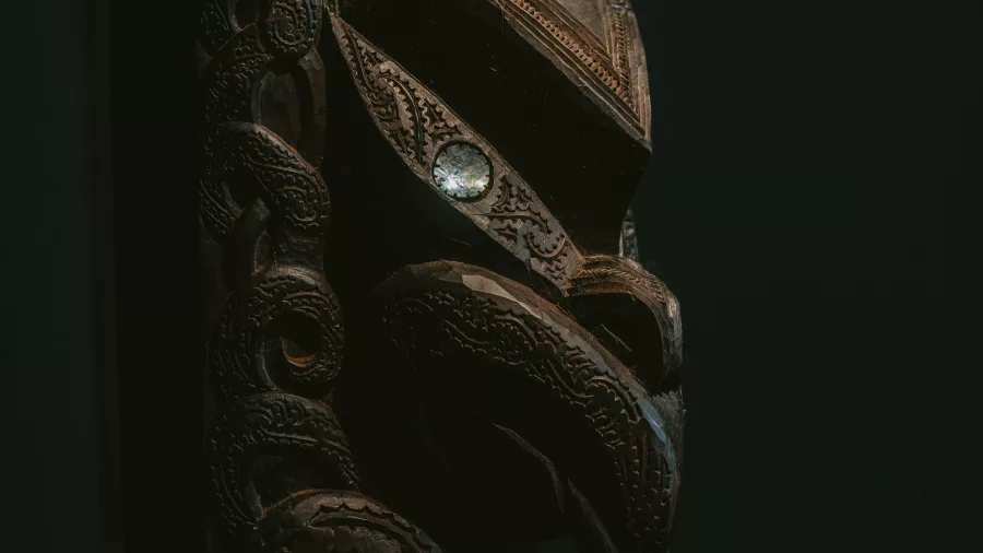 Close-up of a traditional carved pou with intricate Māori designs at Te Puia, Rotorua