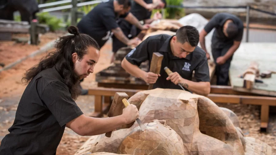 Māori carver working on traditional woodwork at the National Carving School in Te Puia, Rotorua