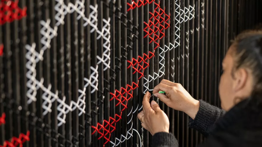 Māori artist weaving a tukutuku panel at the New Zealand Māori Arts and Crafts Institute, Te Puia, Rotorua