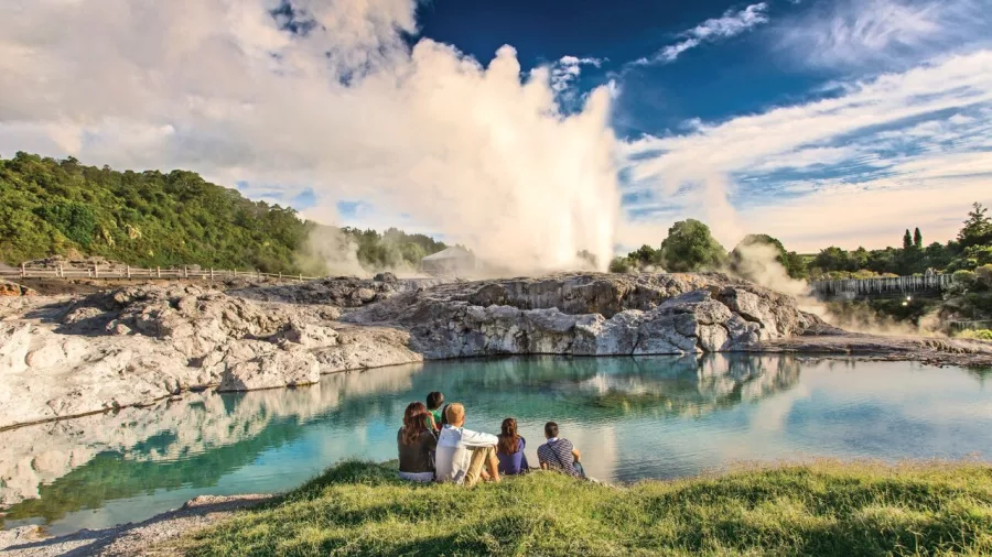 Steam rising from geothermal features in the Te Puia valley, with boardwalk access through a volcanic Rotorua landscape