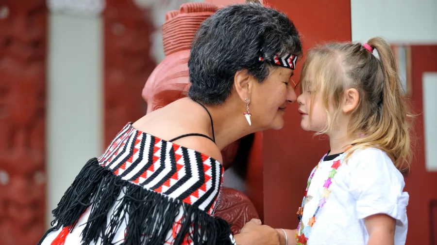 Māori woman and young girl sharing a hongi greeting at Te Puia in Rotorua