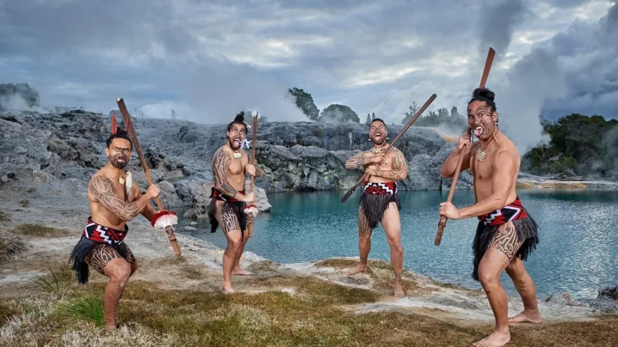 Māori performers in traditional dress holding taiaha at Te Puia geothermal valley