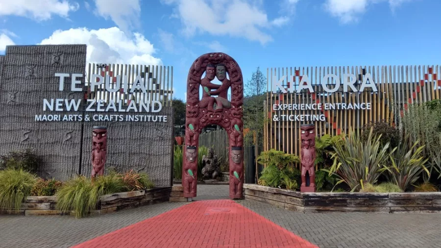 Entrance to Te Puia Maori Arts and Crafts Institute in Rotorua, New Zealand, featuring traditional Māori carvings and welcoming signage