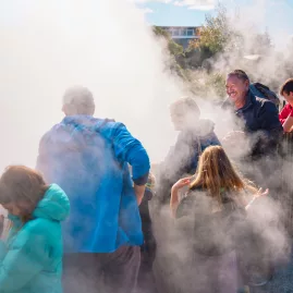 Visitors walking through geothermal steam at Whakarewarewa Māori Village in Rotorua