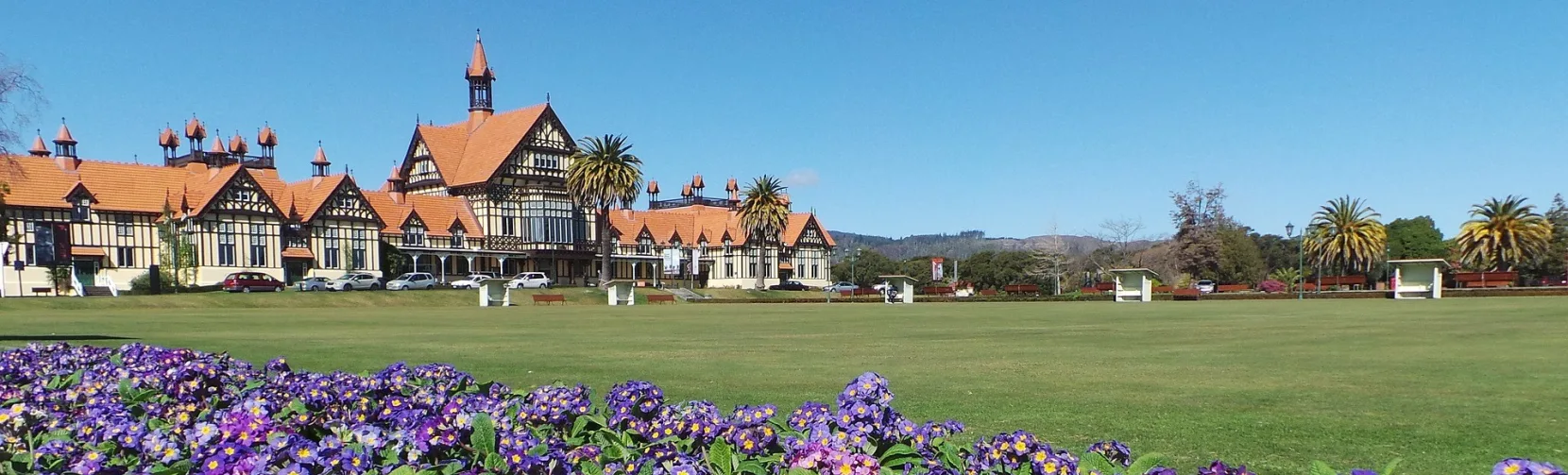 Purple flowers in front of historic Government Gardens building in Rotorua