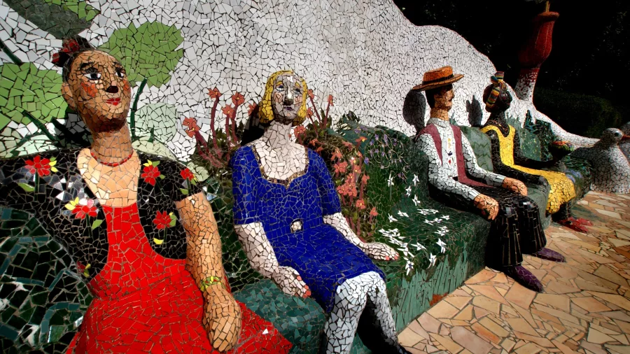 Colourful mosaic sculptures of seated figures at The Giants House in Akaroa, New Zealand