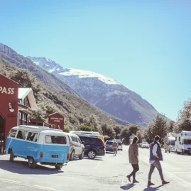 Arthur’s Pass village store with visitors and a snowy mountain backdrop