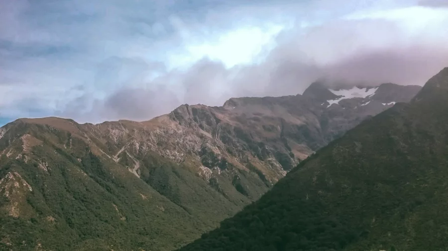 Scenic view of a lush alpine valley and towering mountains in Arthur’s Pass